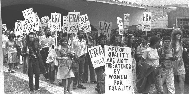 A group of men and women march together holding signs while participating in an ERA protest in Pittsburgh, PA, 1976. (Photo by Barbara Freeman/Getty Images)