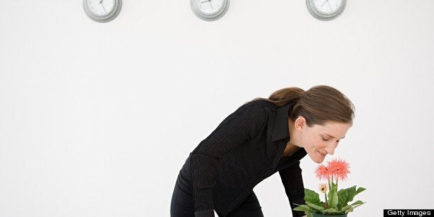 Businesswoman smelling a flower