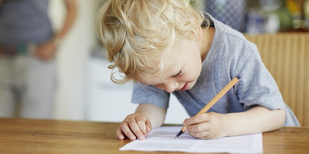 Boy writing on paper at table