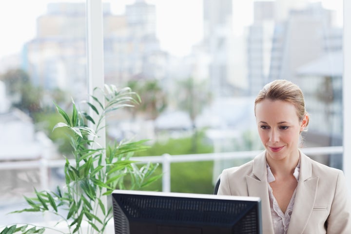 Woman working on a computer with city view in background