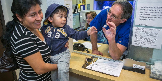 Pediatrician Charles Goodman, talks with patient Carmen Lopez, 37, holding her 18-month-old son, Daniel after being vaccinated with the measles-mumps-rubella vaccine, or MMR at his practice in Northridge, Calif., Thursday, Jan. 29, 2015. Some doctors are adamant about not accepting patients who don't believe in vaccinations, with some saying they don't want to be responsible for someone's death from an illness that was preventable. Others warn that refusing treatment to such people will just send them into the arms of quacks. (AP Photo/Damian Dovarganes)