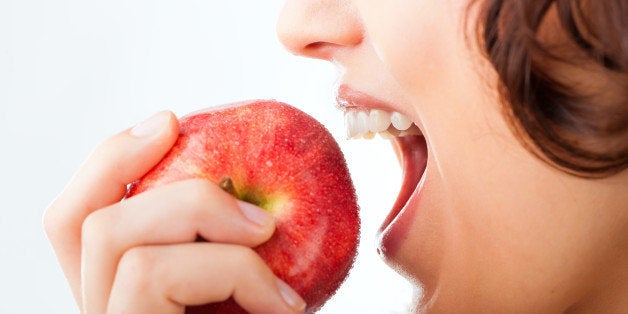 Healthy nutrition and healthy teeth or diet, young woman bites in a apple