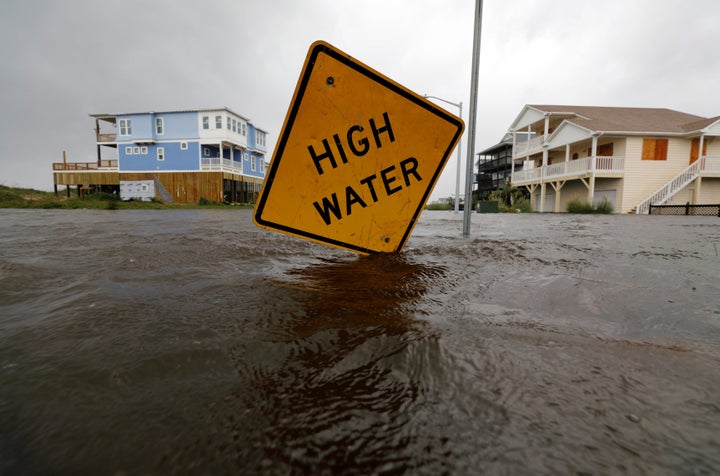 Flood waters lap at a high water warning sign that was partially pushed over by Hurricane Florence on Oak Island, North Carol