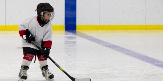 Little boy playing ice hockey