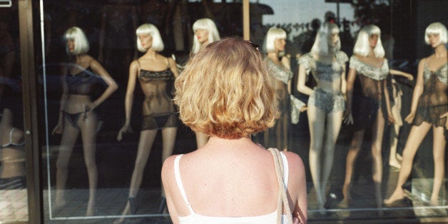 Woman looking at mannequins in store window