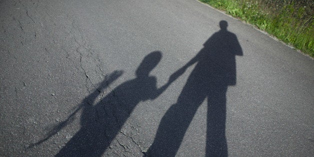 Shadow of father and boy on road