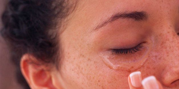 Woman applying lotion to puffy eyes