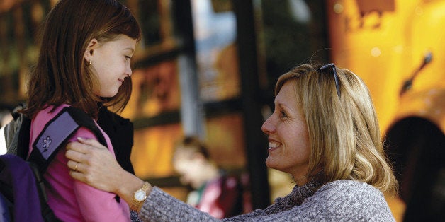 Mother and daughter at school bus stop