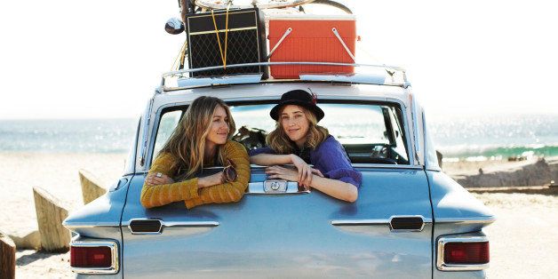 Two girls hanging out in the back of a car.