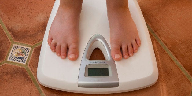 A child being weighed on a set of digital scales.