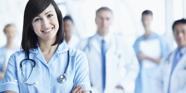 Portrait of a young nurse with her team in the background