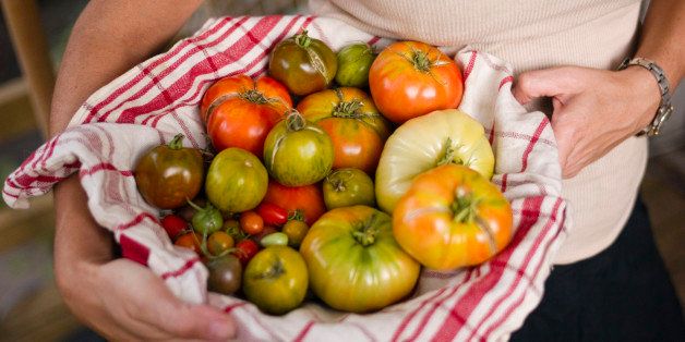 Woman holding bowl of organic tomatoes