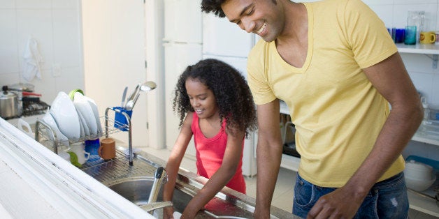 Father and daughter washing dishes.