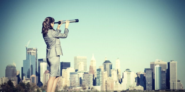 Business woman with spyglass looking for new business opportunities.