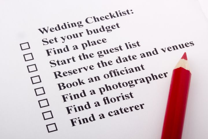 Red pencil laying on a wedding checklist.