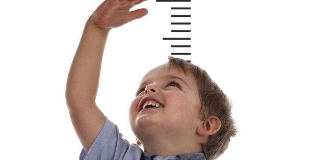 Young boy measuring his growth in height