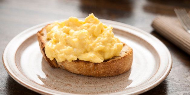 Steaming hot scrambled egg on white toast.