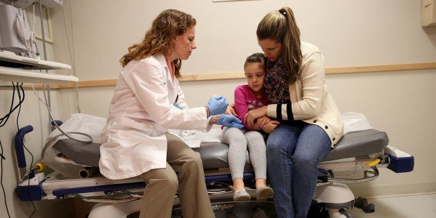 MIAMI, FL - JANUARY 28: Miami Children's Hospital pediatrician Dr. Amanda Porro, M.D prepares to administer a measles vaccination to Sophie Barquin,4, as her mother Gabrielle Barquin holds her during a visit to the Miami Children's Hospital on January 28, 2015 in Miami, Florida. A recent outbreak of measles has some doctors encouraging vaccination as the best way to prevent measles and its spread. (Photo by Joe Raedle/Getty Images)