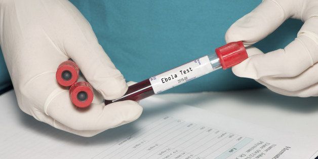 Blood collection tube with Ebola test label held by technician.