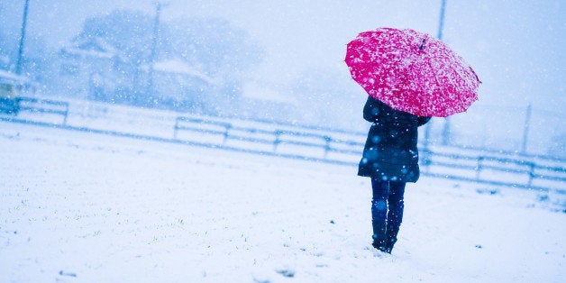 Woman holding a red umbrella on a snowy day.