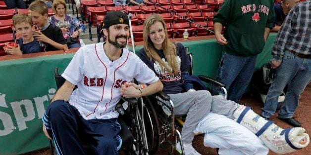 In this Thursday, May 23, 2013 photo, Boston Marathon bombing survivor Pete DiMartino, of Rochester, N.Y., and his girlfriend, Rebekah Gregory, hold hands prior to DiMartino throwing out the ceremonial first pitch before a Red Sox game at Fenway Park in Boston. DiMartino and Gregory were injured in an explosion near the finish line of the Boston Marathon. ᅢ까タᅡワI donᅢ까タᅡルt want anybody feeling sorry for me,ᅢ까タᅡン he said. ᅢ까タᅡワ... I want people to see that this has made me a better person and I want people to become better people through what they see through me.ᅢ까タᅡン (AP Photo/Charles Krupa)