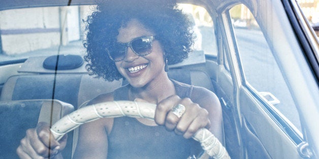 Mixed race woman driving vintage car