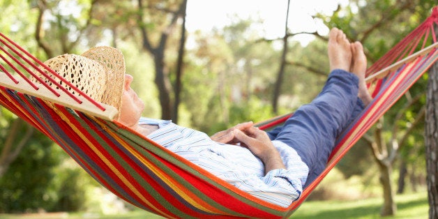 Senior Man Relaxing In Hammock Alseep In Sunshine