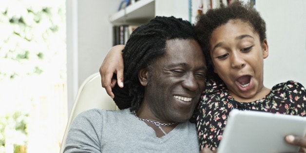 Man and daughter using tablet computer