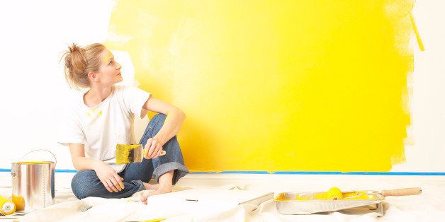 Young woman sitting on the floor , holding a paintbrush