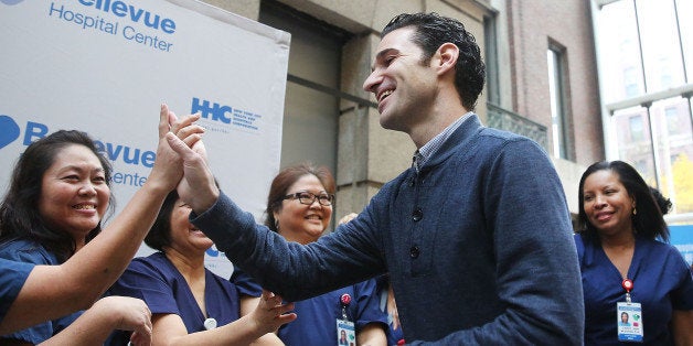 NEW YORK, NY - NOVEMBER 11: Dr. Craig Spencer, who was diagnosed with Ebola in New York City last month, greets some of the nurses who helped him to recovery at a news conference at New York's Bellevue Hospital after being declared free of the disease on November 11, 2014 in New York City. Spencer, a 33 year old Doctors Without Borders physician, was diagnosed last month after returning from treating patients in Guinea. He became the first person to test positive for the deadly virus in the New York City and was treated in isolation at the hospital. Spencer's case started a controversy about voluntary quarantine after he travelled the city in the days after returning from Africa unaware that he was carrying the virus. After being released, Spencer he is expected to return to his apartment in the New York City neighborhood of Hamilton Heights. (Photo by Spencer Platt/Getty Images)