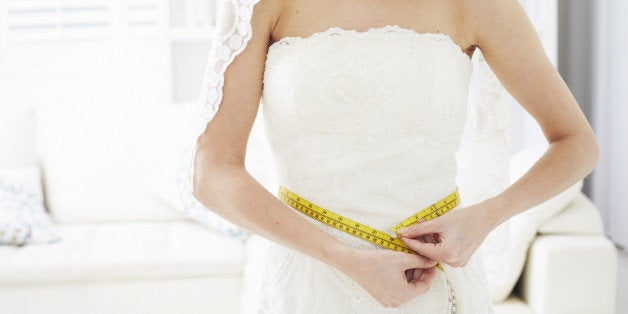 Bride measuring her waistline