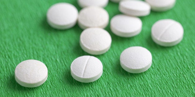 Close-Up of White Melatonin Natural Medicine Sleeping Pills on Green Background