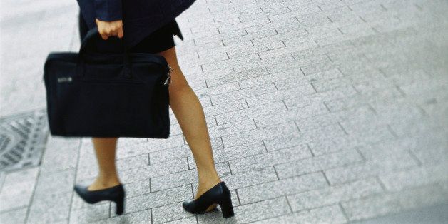 Businesswoman walking on sidewalk, cropped view