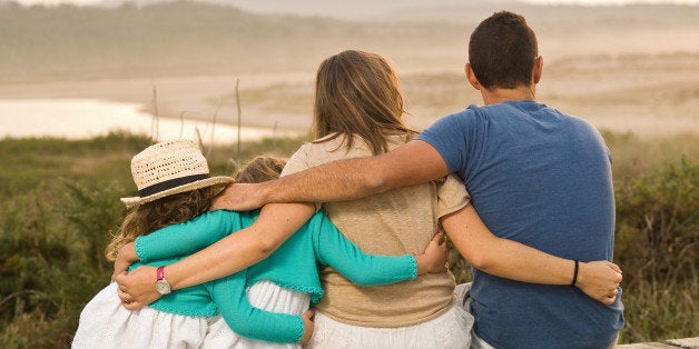 Family together and embracing on the beach