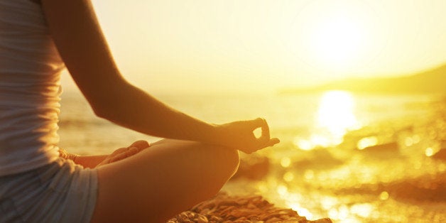 hand of a woman meditating in a yoga pose on the beach