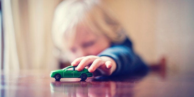 Little boy playing with toy car.