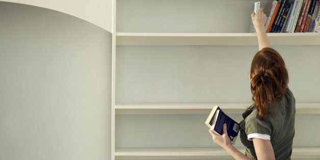 Woman removing books from the shelf