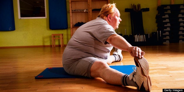 overweight man exercising stretching flexibility