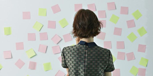 Woman looking at sticky notes on board