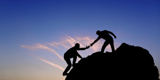 Silhouette of helping hand between two climber