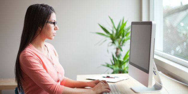 Young woman using desktop computer in home office