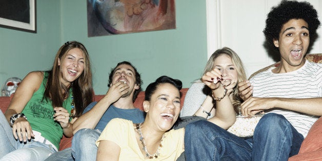 Friends laughing watching TV together