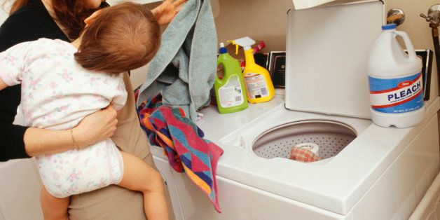 Mother and child (21-24 months) doing laundry