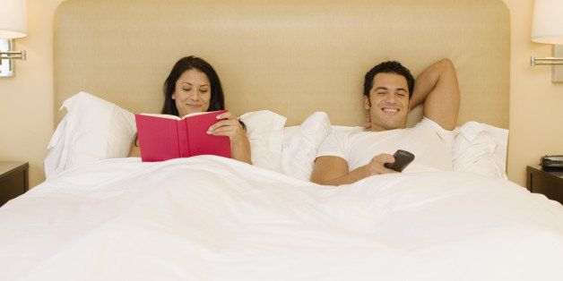 Smiling couple with book and remote control