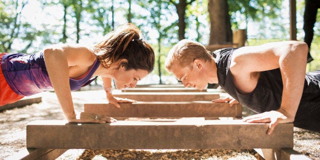 Side view of couple doing push-ups at outdoor gym