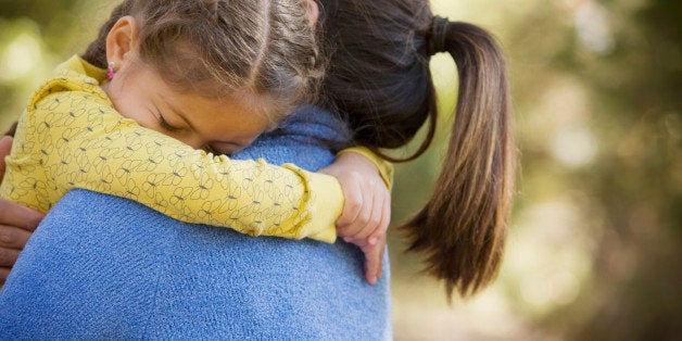 Hispanic woman carrying daughter