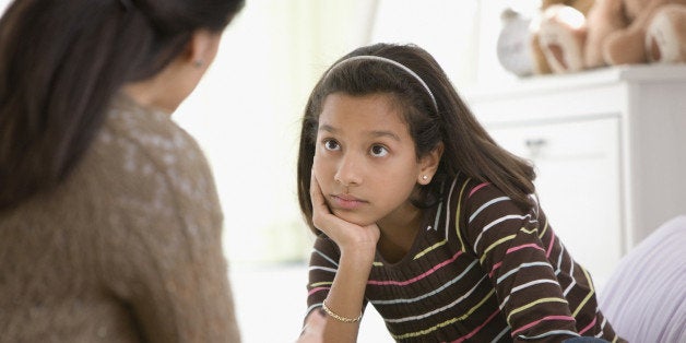 Mother talking to daughter in bedroom