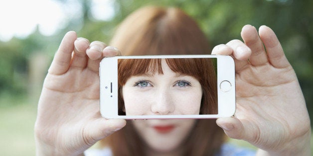 woman holding up mobile with selfie