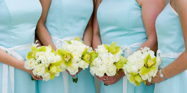 Four bridesmaids holding bouquets, mid section