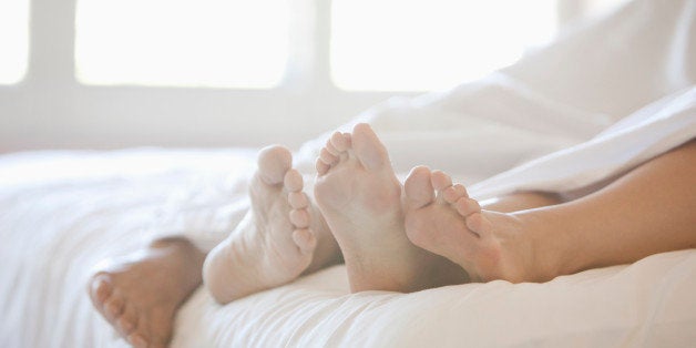 Close up of couple's feet in bed